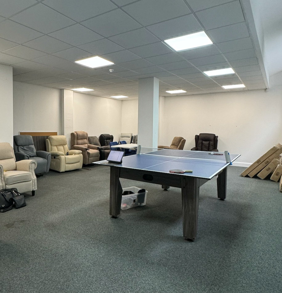 Game room with ping pong table, recliner chairs, and a couch.