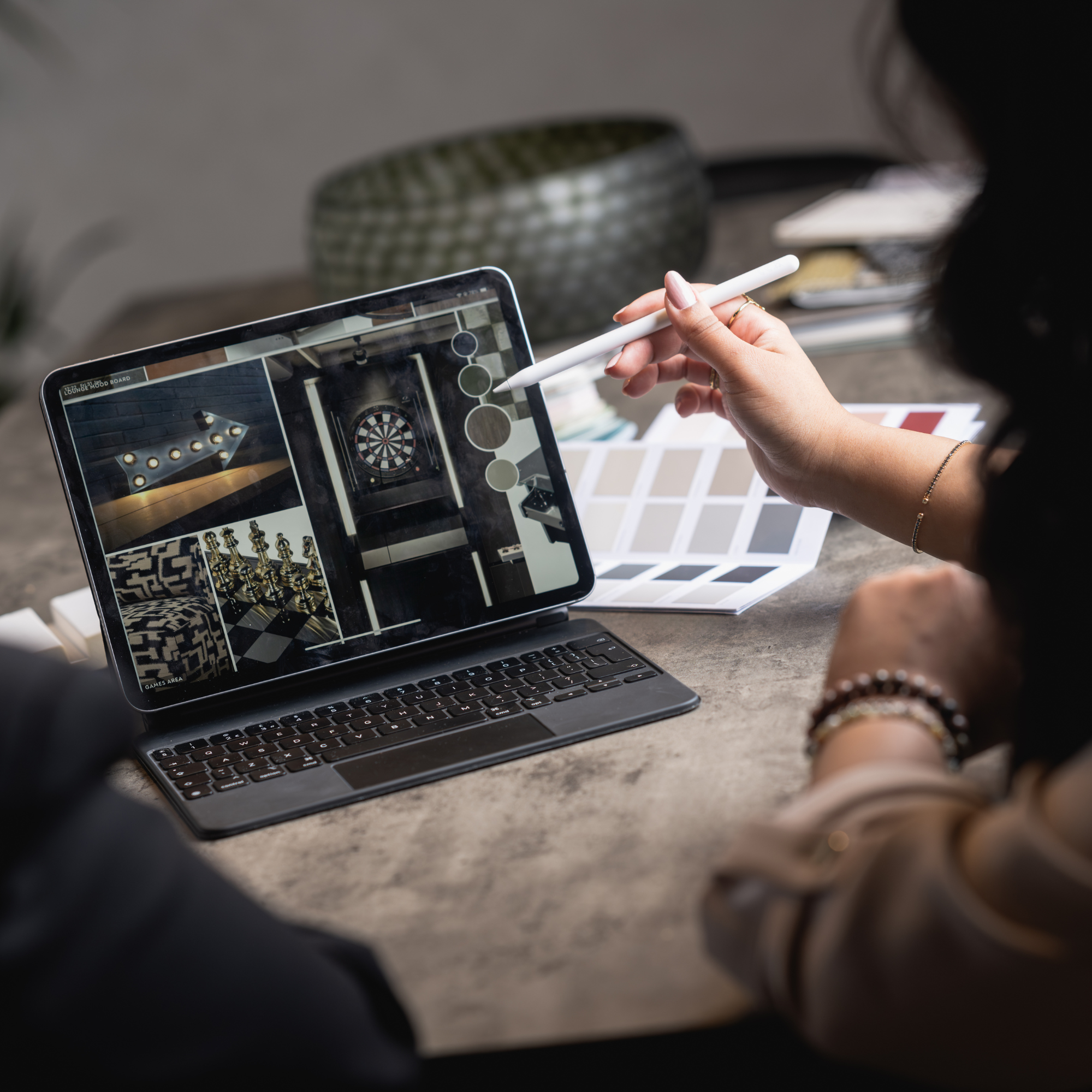 Interior designer reviewing commercial space mood boards and material palettes on a digital tablet